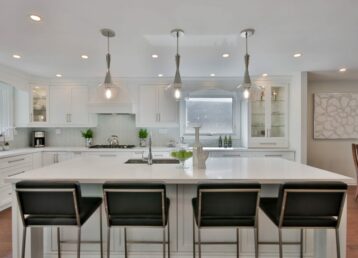 White kitchen with four black chairs at the island